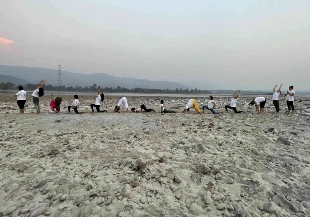 Gyan yog breath Yoga group practicing Moon salutation - chandra namaskar at beach