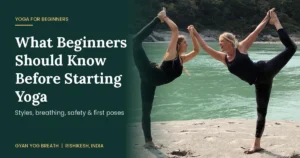 Beginner yoga students practising Tadasana on mats near the Ganges in Rishikesh